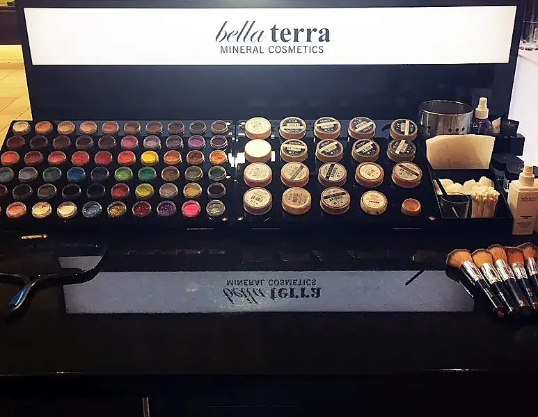Tray of BELLATERRA mineral eyeshadows and foundations under the kiosk light box